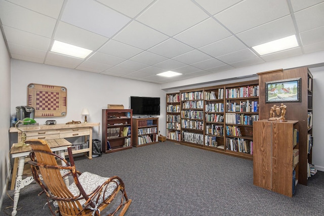 sitting room featuring carpet floors and a drop ceiling