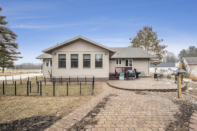 back of house featuring a patio area, a shingled roof, a gate, and fence