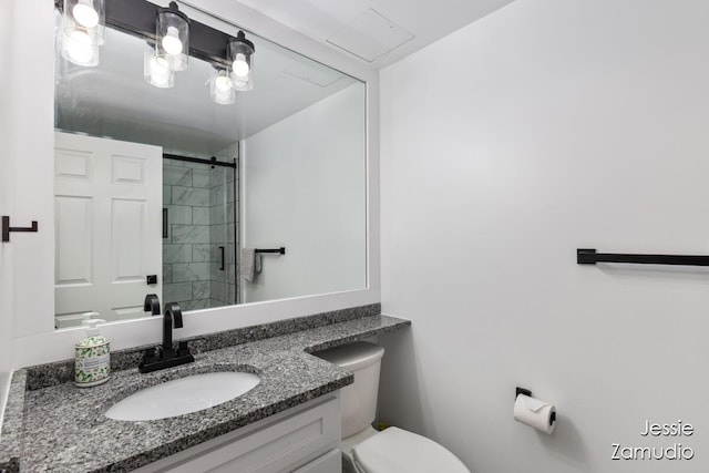 bathroom with a stall shower, vanity, and toilet