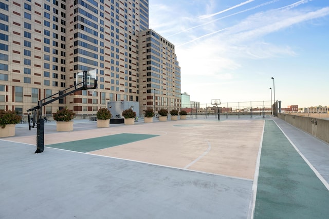 view of home's community with community basketball court and fence