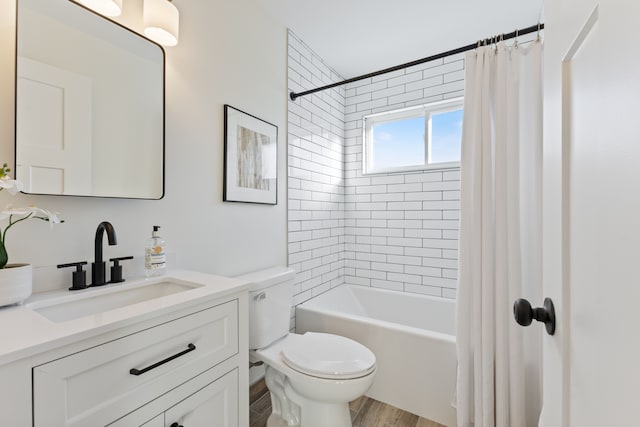 full bathroom with wood finished floors, shower / tub combo, vanity, and toilet