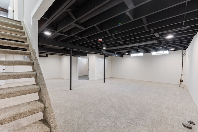 basement with stairs and carpet flooring