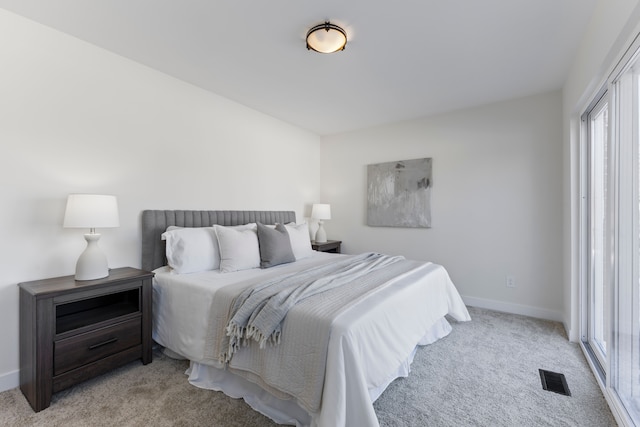 bedroom with light colored carpet, visible vents, and baseboards