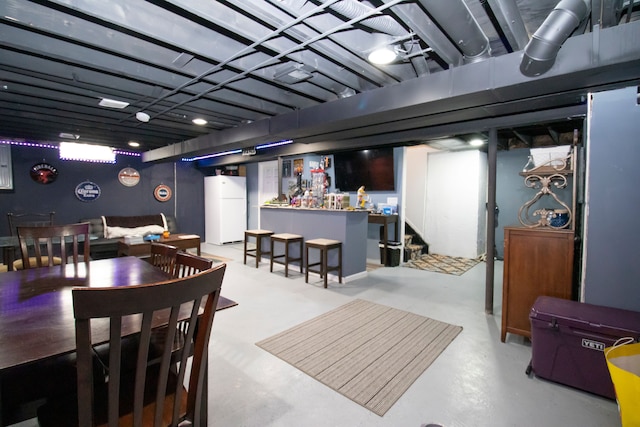 interior space featuring freestanding refrigerator, a dry bar, and stairs