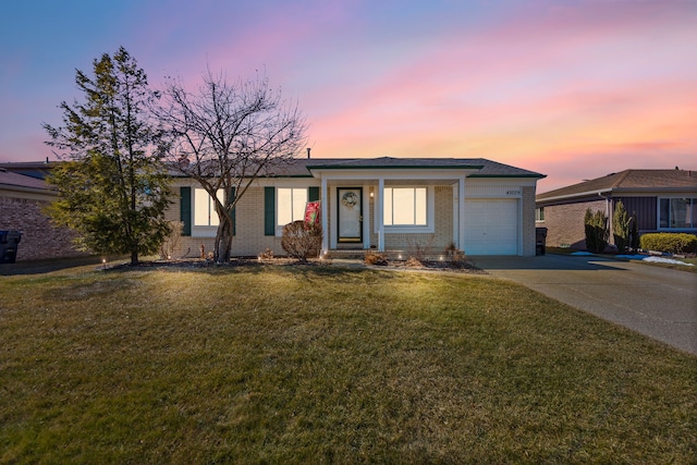 ranch-style house featuring an attached garage, a front yard, concrete driveway, and brick siding