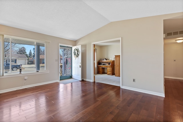 entryway with lofted ceiling, baseboards, visible vents, and wood finished floors