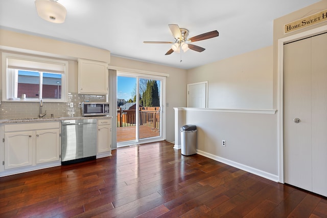 kitchen featuring stainless steel appliances, white cabinetry, dark wood finished floors, and decorative backsplash