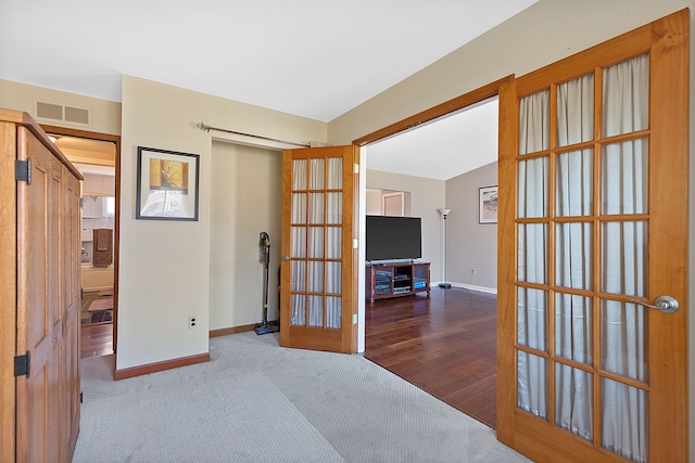 empty room with baseboards, visible vents, carpet flooring, and french doors