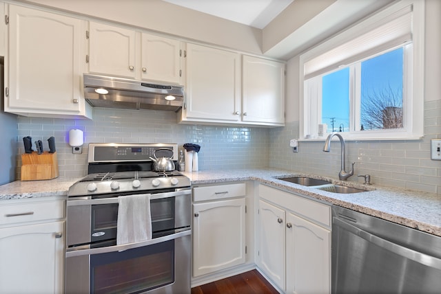 kitchen featuring under cabinet range hood, white cabinetry, appliances with stainless steel finishes, and a sink