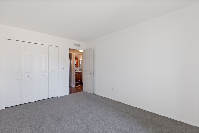 unfurnished bedroom featuring baseboards, carpet, visible vents, and a closet