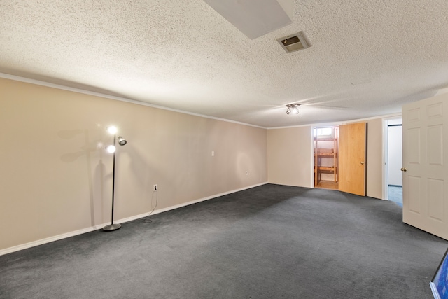 empty room featuring a textured ceiling, dark colored carpet, and visible vents