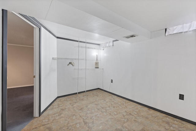 spare room with visible vents, crown molding, and baseboards