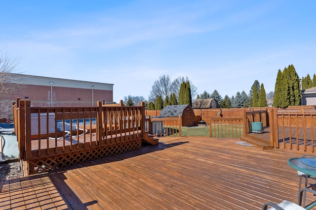 wooden terrace with a shed, an outdoor structure, and fence