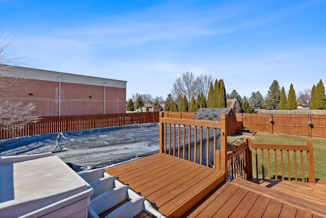 deck with an outbuilding, a storage unit, and a fenced backyard