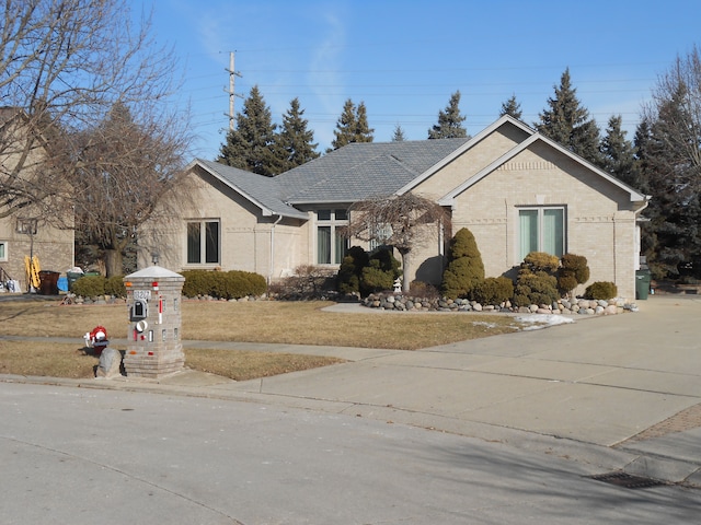 view of front facade with brick siding and a front lawn