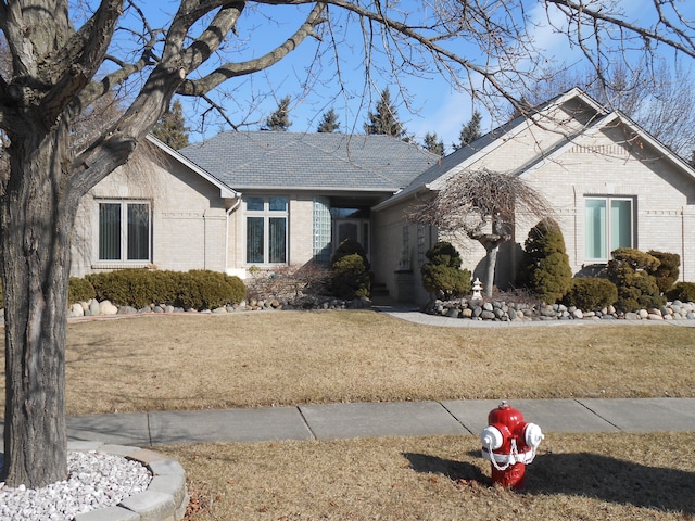 view of front of property with a front yard and brick siding