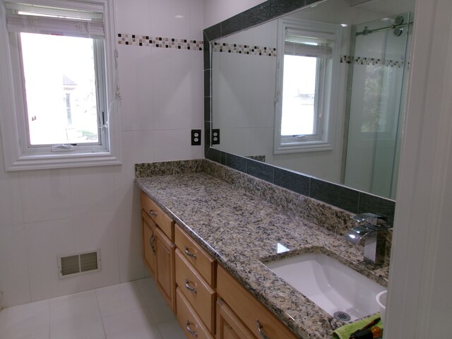 13267 Pearl Dr, Utica, MI 48315 - bathroom with visible vents, tile walls, tile patterned flooring, vanity, and a stall shower