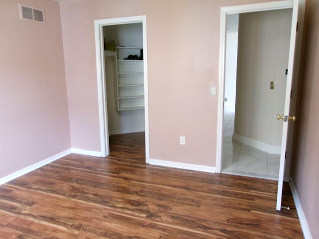 13267 Pearl Dr, Utica, MI 48315 - unfurnished bedroom featuring a closet, baseboards, a walk in closet, visible vents, and wood finished floors