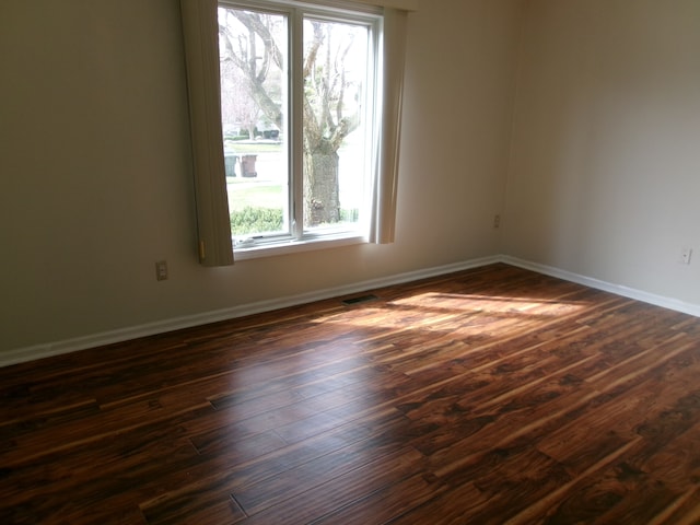 13267 Pearl Dr, Utica, MI 48315 - empty room with dark wood finished floors, visible vents, and a wealth of natural light