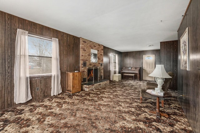 carpeted living room with wood walls and a fireplace