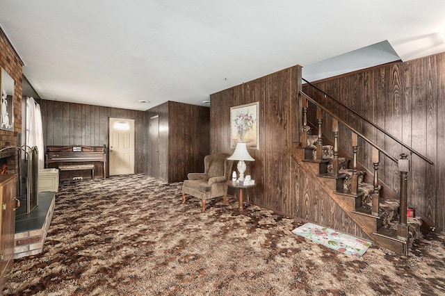 unfurnished room with stairs, wood walls, and carpet