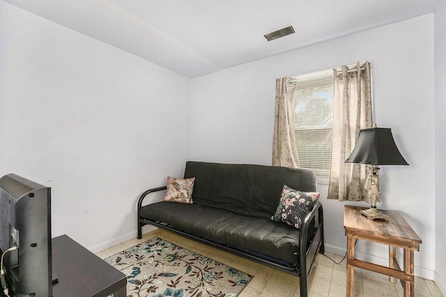 living area with baseboards and visible vents