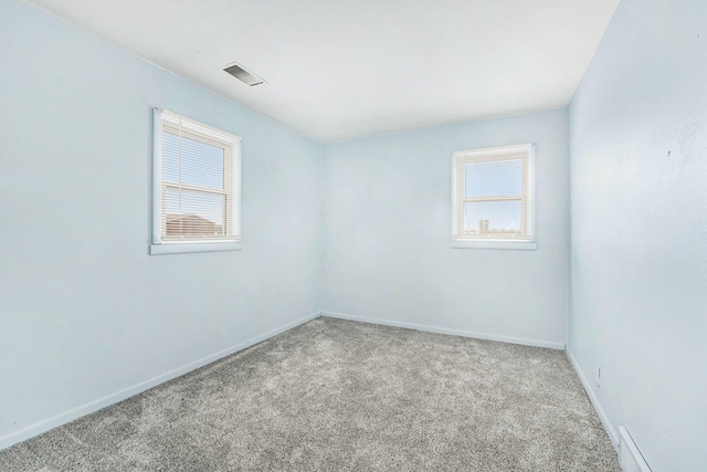 empty room with carpet floors, visible vents, and baseboards