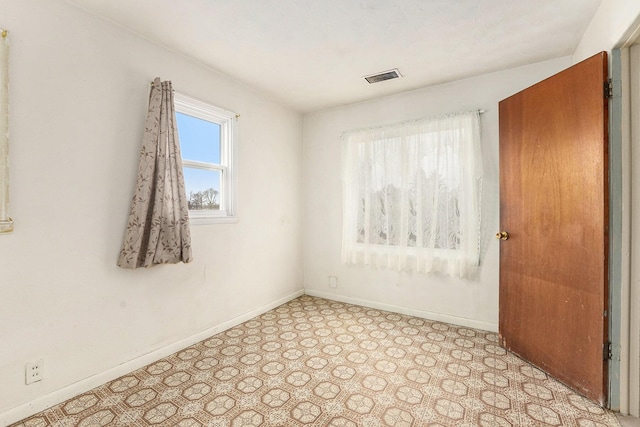 spare room featuring light floors, baseboards, and visible vents