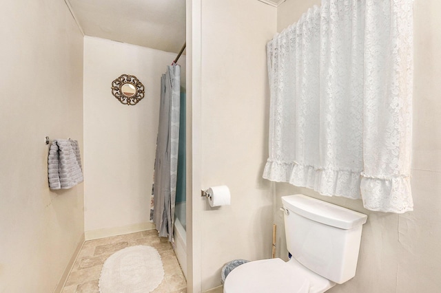 bathroom with toilet, baseboards, and shower / bath combination with curtain