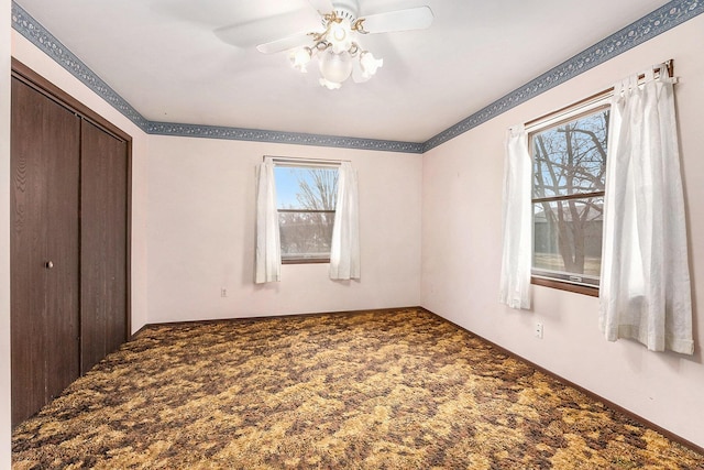 unfurnished bedroom featuring a closet, carpet flooring, and a ceiling fan