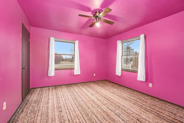 carpeted spare room with a ceiling fan and a wealth of natural light