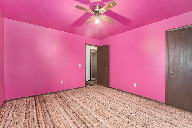 carpeted empty room featuring a ceiling fan