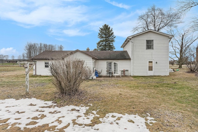 back of property featuring a deck and a lawn