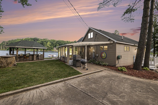 view of front of property with a water view, a front lawn, and a pergola