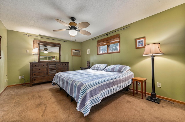 carpeted bedroom with a textured ceiling, ceiling fan, a wall mounted AC, and baseboards