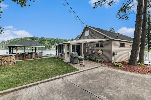 view of front facade with a water view, a patio area, a front lawn, and a pergola