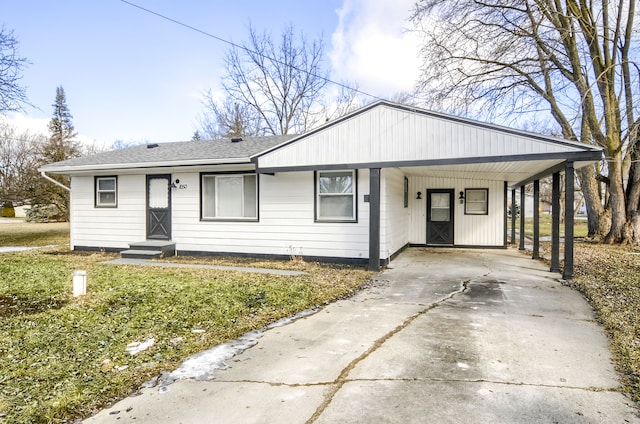 view of front facade featuring an attached carport, concrete driveway, and roof with shingles