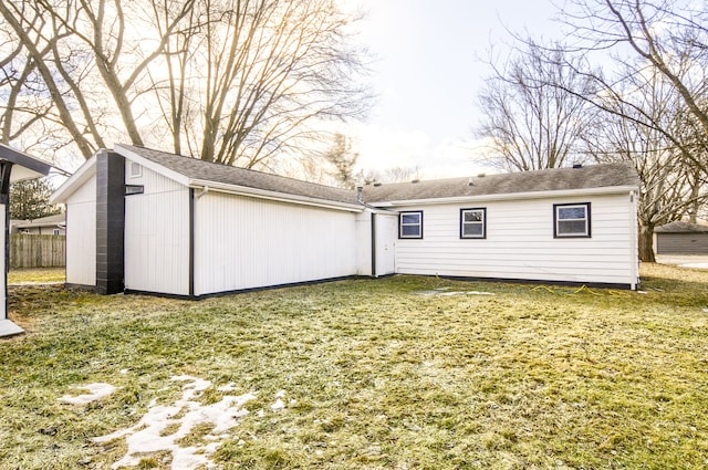 back of property featuring a yard and fence