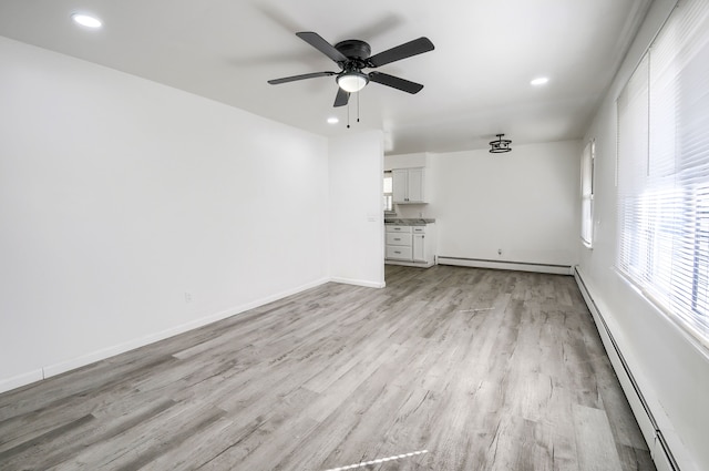 unfurnished living room with a baseboard radiator, light wood-style flooring, recessed lighting, baseboards, and baseboard heating