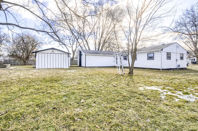 view of yard featuring an outdoor structure, a storage shed, and fence