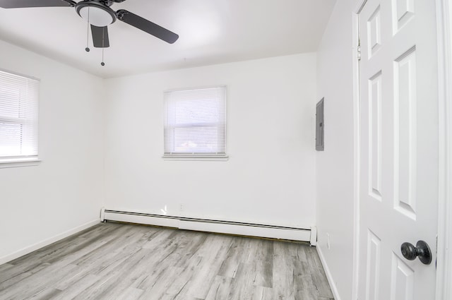 empty room with a baseboard heating unit, a ceiling fan, light wood-style flooring, and baseboards