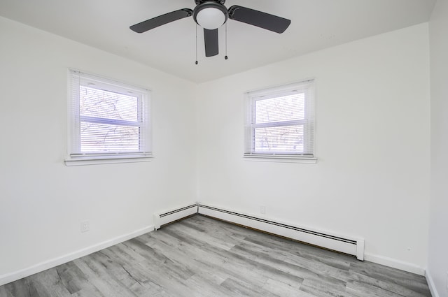 spare room with plenty of natural light, wood finished floors, a baseboard radiator, and baseboards