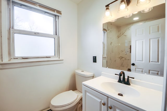 bathroom featuring toilet, walk in shower, and vanity