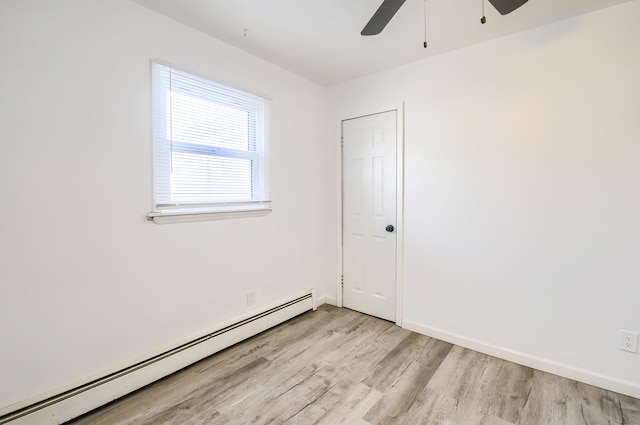 empty room with light wood finished floors, baseboards, a baseboard heating unit, and ceiling fan