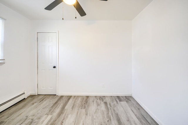 empty room featuring light wood finished floors, baseboards, a baseboard heating unit, and a ceiling fan