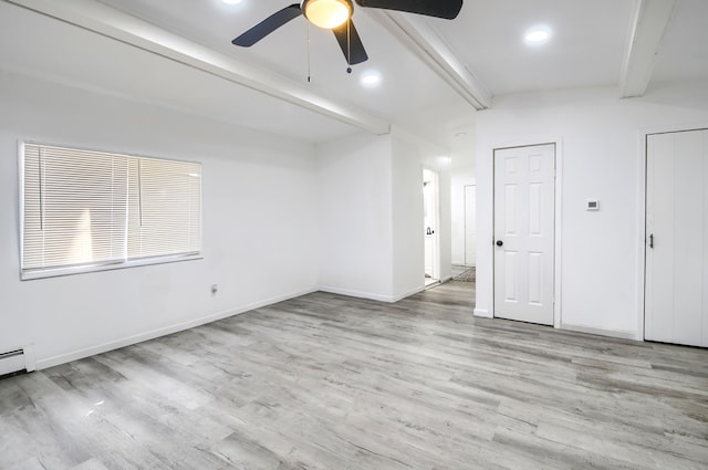 spare room with lofted ceiling with beams, wood finished floors, and baseboards