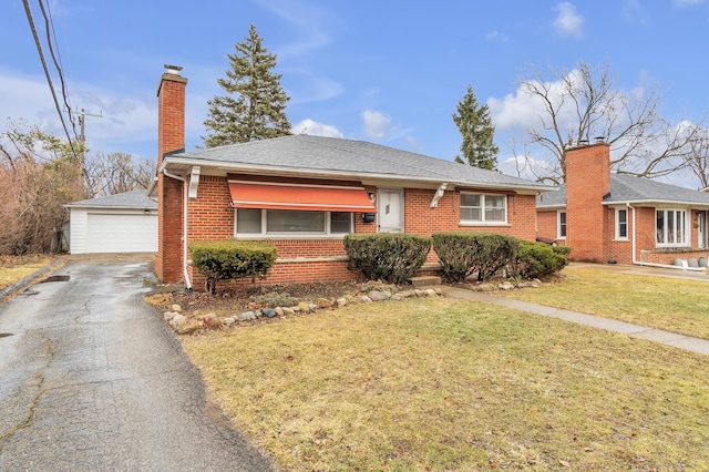 single story home featuring a garage, a chimney, an outbuilding, a front yard, and brick siding