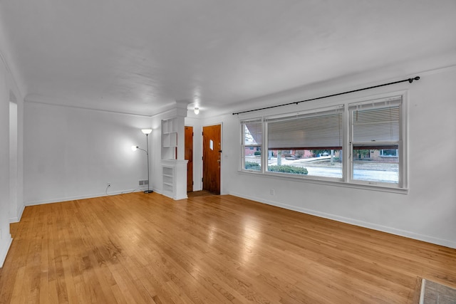 spare room featuring light wood-style flooring and baseboards