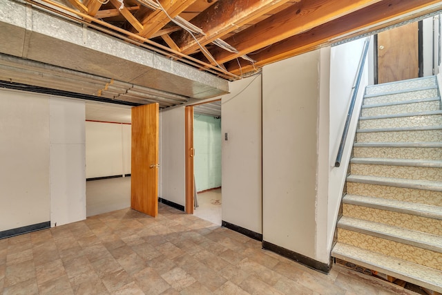 unfinished below grade area featuring stairs and baseboards