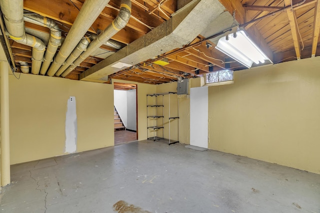 basement featuring electric panel and stairway